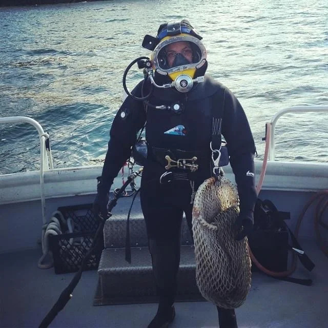Bettina in a diving helmet on a boat