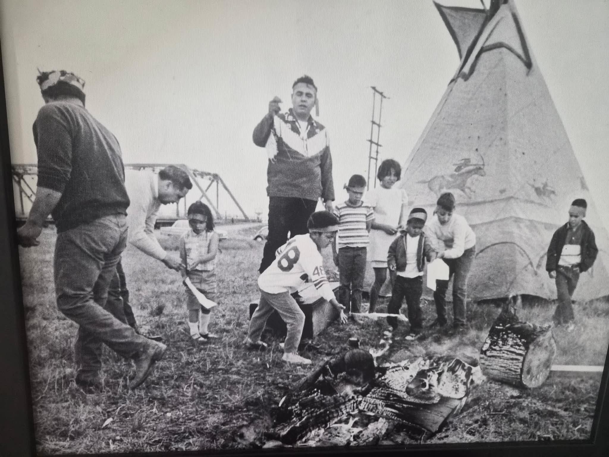 Historic photograph of a Puyallup family gathering beside a teepee